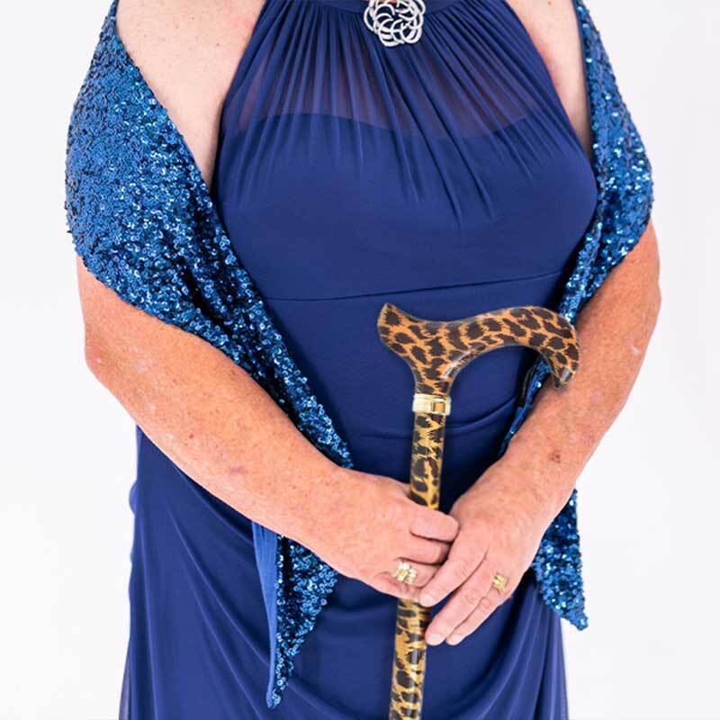 a woman in a dark blue gown holding a leopard print walking stick