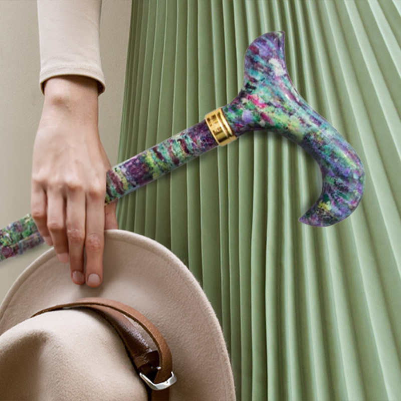 someone in a green skirt holding a floral-patterned walking stick