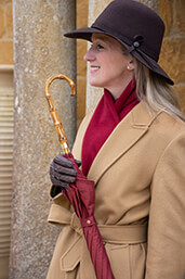 Stylish woman holding burgundy umbrella