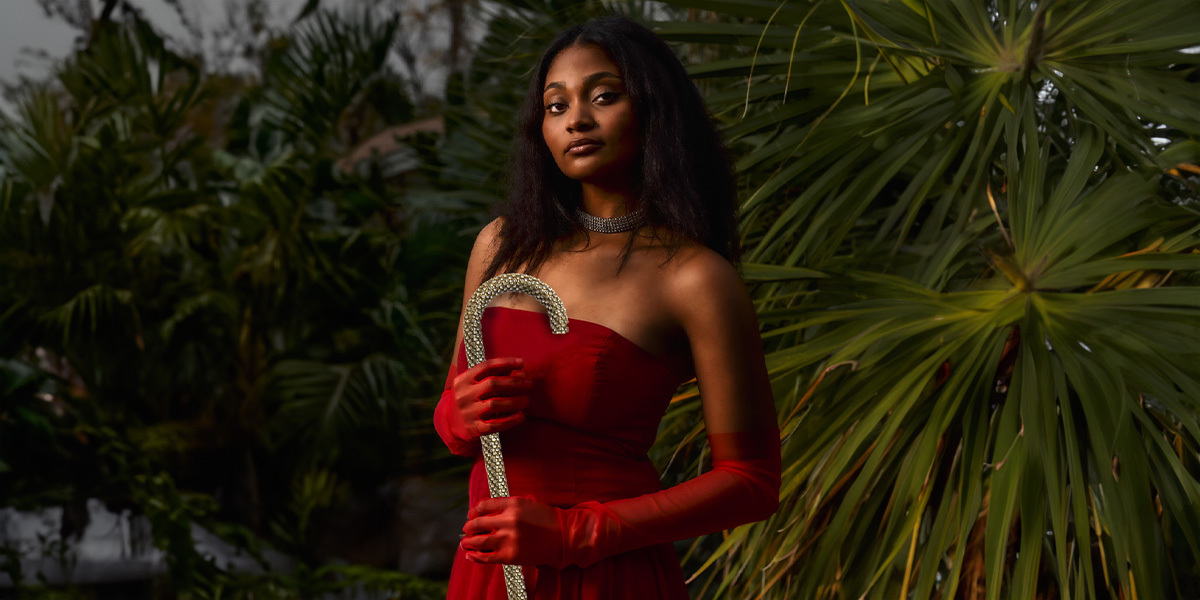 woman in a red dress holding a crook-handle walking stick